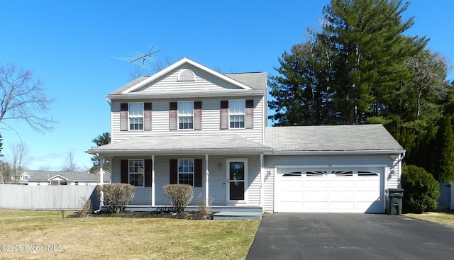 traditional-style home with fence, driveway, a front yard, covered porch, and a garage