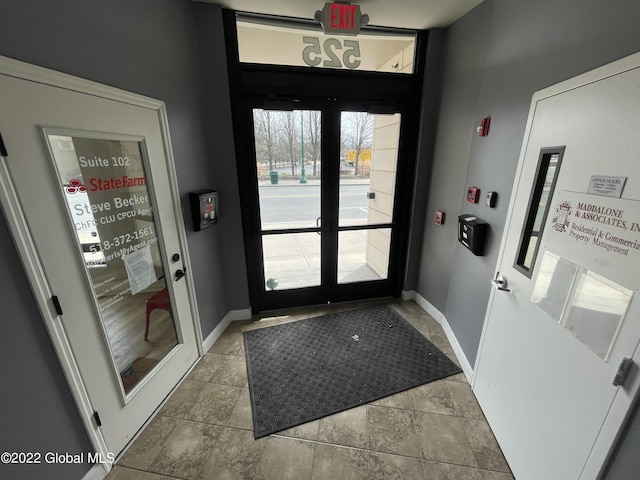 doorway with baseboards and french doors