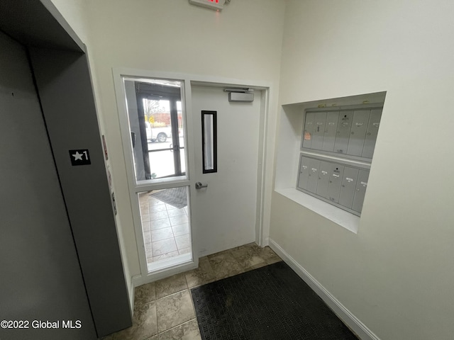 doorway with baseboards and mail area
