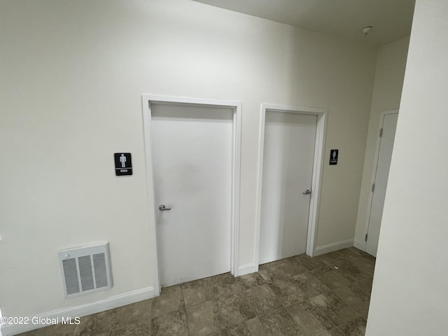 hall featuring baseboards and visible vents