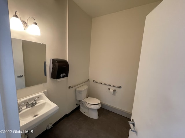 bathroom featuring baseboards, a sink, and toilet