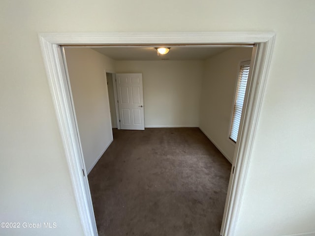 empty room featuring carpet flooring and baseboards