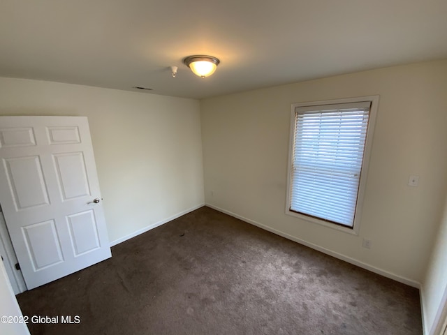 carpeted spare room with baseboards