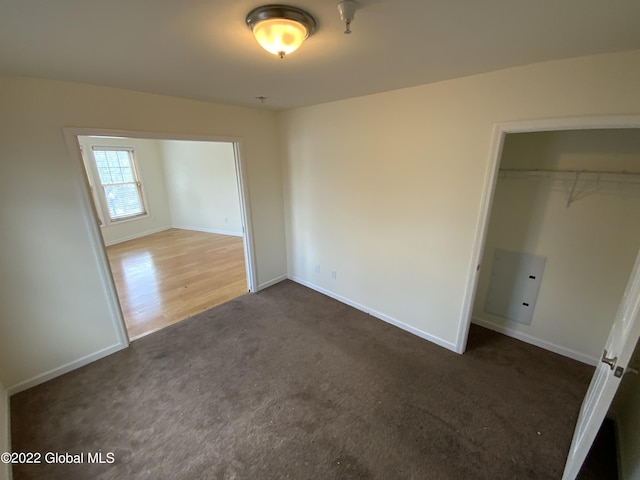 unfurnished bedroom with a closet, carpet flooring, and baseboards