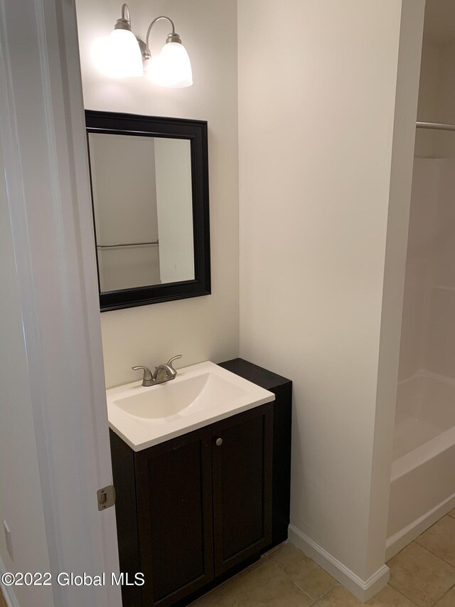 full bath with tile patterned floors, vanity, and baseboards