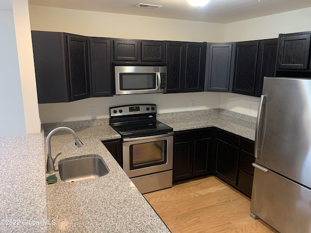 kitchen featuring a sink, visible vents, dark cabinets, and appliances with stainless steel finishes