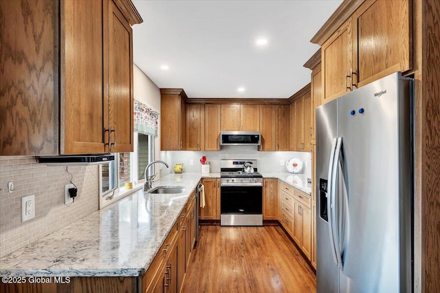 23 Leggett Rd, Ghent, NY 12075 - kitchen with a sink, light stone counters, appliances with stainless steel finishes, brown cabinetry, and wood finished floors