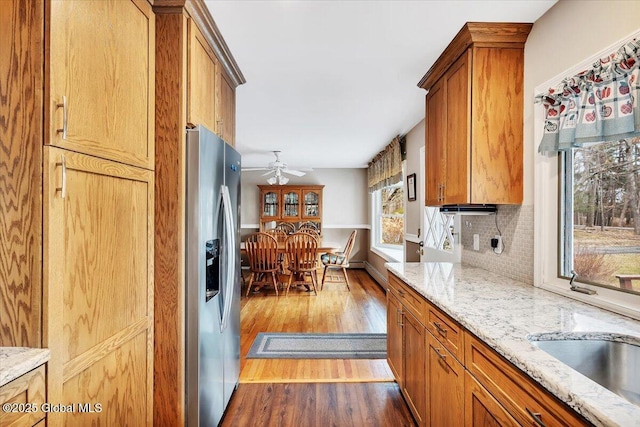 23 Leggett Rd, Ghent, NY 12075 - kitchen with stainless steel fridge, wood finished floors, a ceiling fan, tasteful backsplash, and brown cabinetry