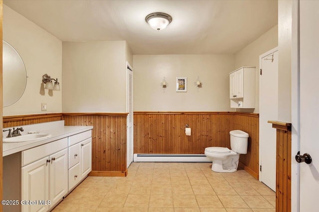 23 Leggett Rd, Ghent, NY 12075 - bathroom with vanity, toilet, wooden walls, a baseboard radiator, and wainscoting