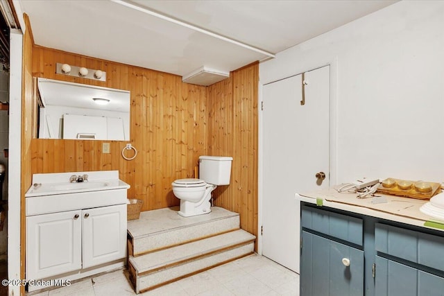 23 Leggett Rd, Ghent, NY 12075 - bathroom with tile patterned floors, wooden walls, toilet, and vanity