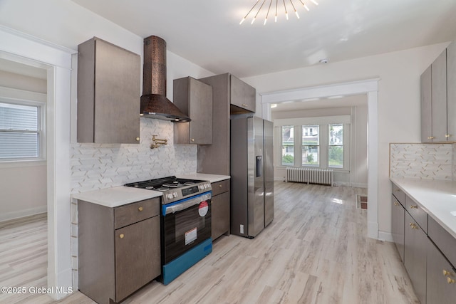 22 Fairlawn Ave, Albany, NY 12203 - kitchen featuring stainless steel appliances, wall chimney exhaust hood, radiator heating unit, and light countertops