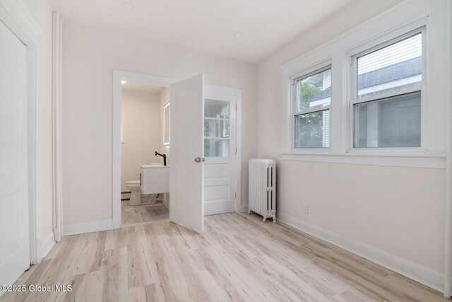 22 Fairlawn Ave, Albany, NY 12203 - unfurnished bedroom with radiator heating unit, light wood-style flooring, baseboards, and ensuite bathroom