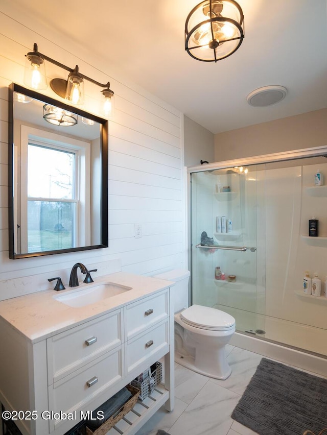 bathroom with vanity, marble finish floor, toilet, and a shower stall