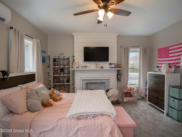 bedroom with a fireplace, a wall mounted AC, carpet, and a ceiling fan