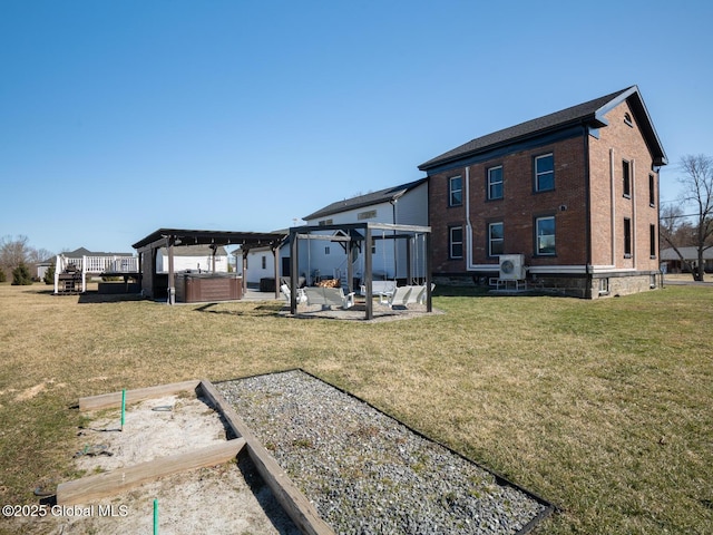 rear view of house featuring a garden, a pergola, a hot tub, a yard, and a patio area
