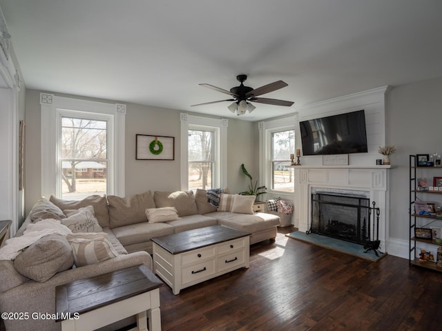 living area featuring dark wood-style floors, a fireplace, and a ceiling fan