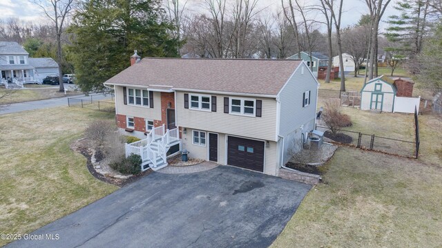 7 Bemis Heights Rd, Saratoga Springs, NY 12866 - split foyer home with aphalt driveway, fence, a storage unit, a front lawn, and roof with shingles