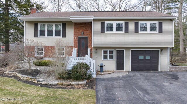 7 Bemis Heights Rd, Saratoga Springs, NY 12866 - raised ranch featuring a chimney, driveway, brick siding, a garage, and a shingled roof
