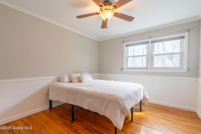 7 Bemis Heights Rd, Saratoga Springs, NY 12866 - bedroom with a ceiling fan, light wood-style floors, ornamental molding, and a wainscoted wall