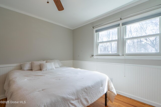 7 Bemis Heights Rd, Saratoga Springs, NY 12866 - bedroom featuring wainscoting, crown molding, a ceiling fan, and wood finished floors