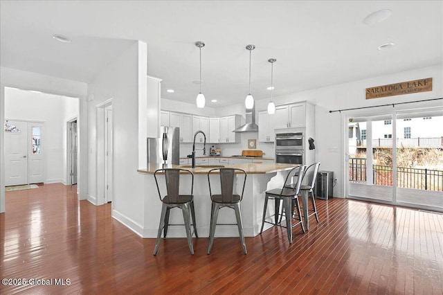 kitchen with a peninsula, appliances with stainless steel finishes, a sink, and a healthy amount of sunlight