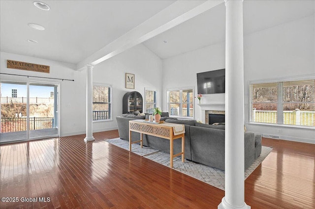 living area featuring ornate columns, a fireplace, baseboards, and hardwood / wood-style flooring