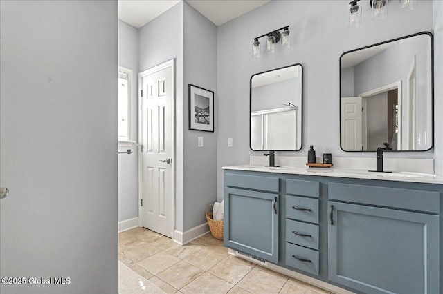 bathroom featuring a sink, baseboards, double vanity, and tile patterned flooring