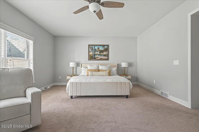 carpeted bedroom featuring visible vents, baseboards, and ceiling fan
