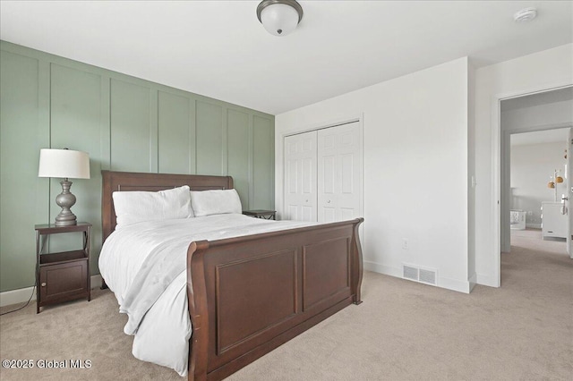 bedroom with a closet, visible vents, light colored carpet, and baseboards