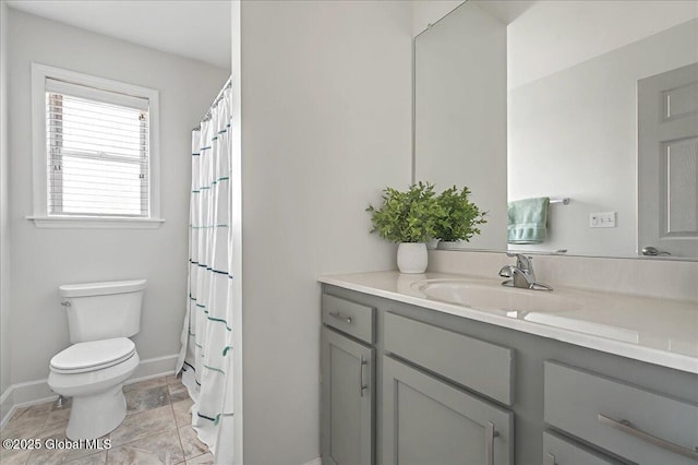 full bath featuring toilet, vanity, and baseboards