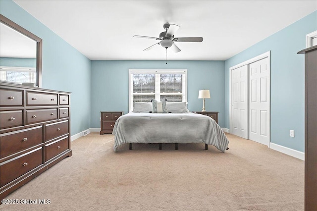 bedroom with light colored carpet, multiple windows, and baseboards