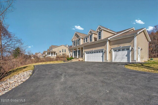 view of front facade featuring a garage and aphalt driveway
