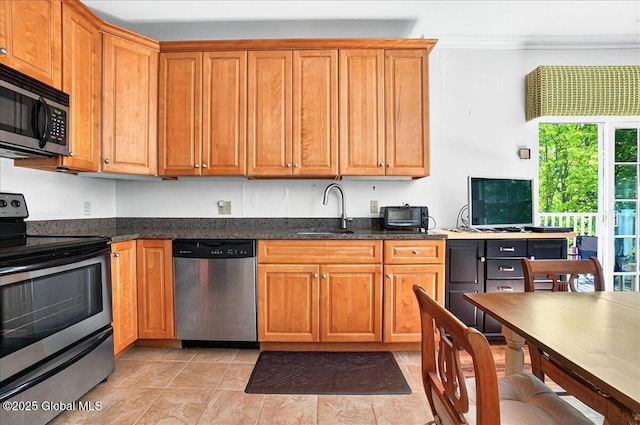 8 Wall St Apt 200, Clifton Park, NY 12065 - kitchen featuring stainless steel appliances, a sink, crown molding, brown cabinets, and dark stone countertops