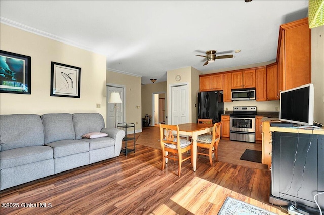 8 Wall St Apt 200, Clifton Park, NY 12065 - kitchen featuring appliances with stainless steel finishes, open floor plan, ornamental molding, dark wood finished floors, and ceiling fan