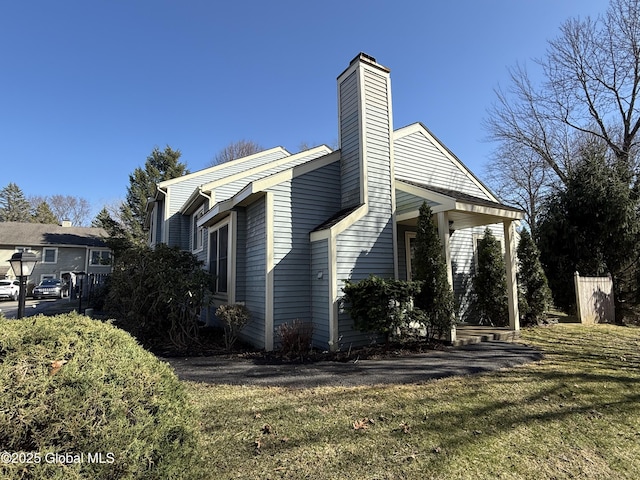view of property exterior featuring a yard and a chimney