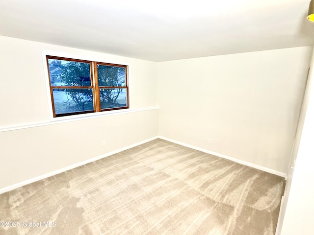 empty room with light colored carpet and baseboards