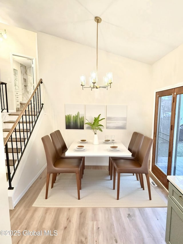 dining area with a notable chandelier, baseboards, stairway, and light wood finished floors