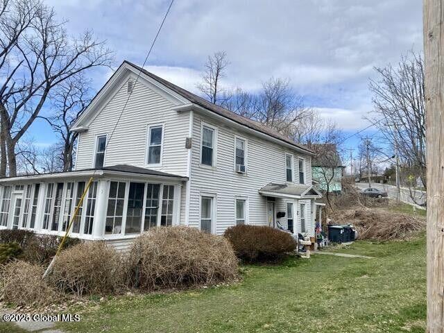 back of house featuring a sunroom and a yard
