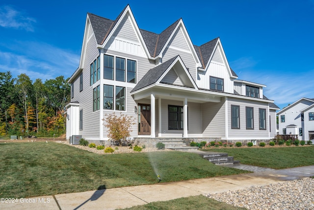 view of front of house featuring central AC unit, a front lawn, board and batten siding, and a porch