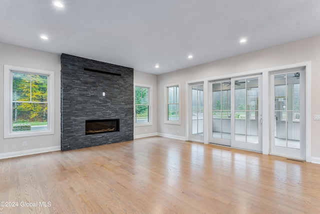 unfurnished living room featuring light wood finished floors, baseboards, and a fireplace