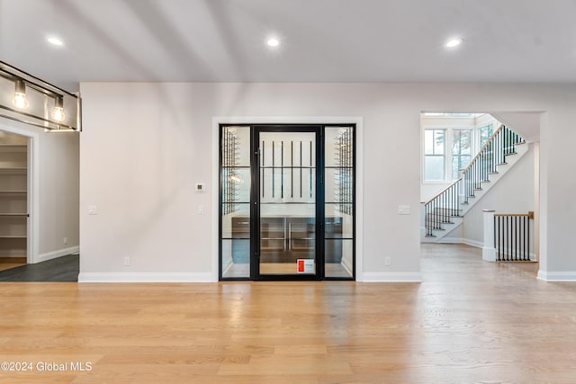 interior space featuring baseboards, stairs, light wood-style flooring, and recessed lighting