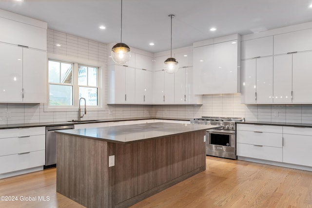 kitchen with modern cabinets, dark countertops, ventilation hood, and appliances with stainless steel finishes