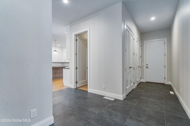 corridor with baseboards, visible vents, and recessed lighting