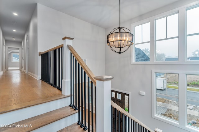 staircase featuring baseboards, a chandelier, and recessed lighting