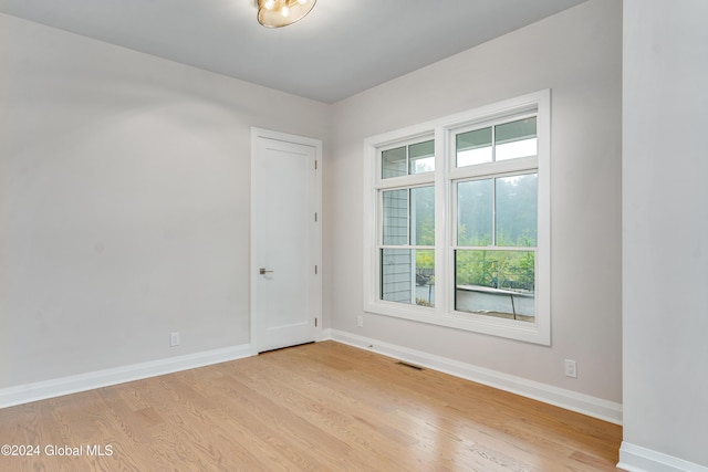 empty room featuring baseboards, visible vents, and light wood-style flooring
