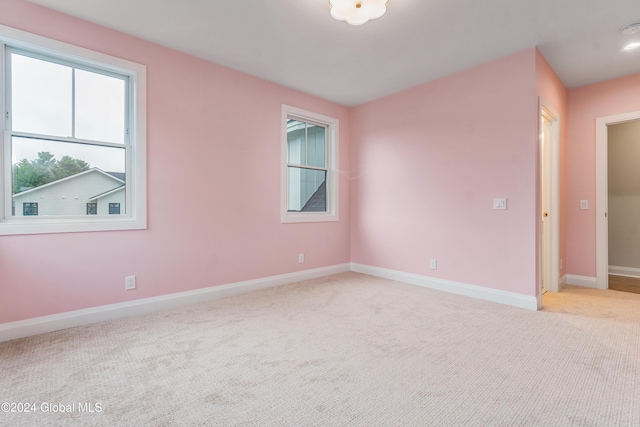 spare room featuring baseboards and carpet floors