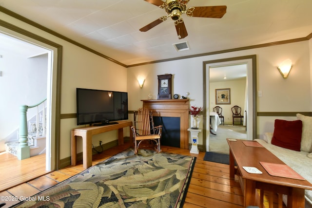 21 Andrews St, Saratoga Springs, NY 12866 - living area with crown molding, hardwood / wood-style flooring, a fireplace, visible vents, and ceiling fan