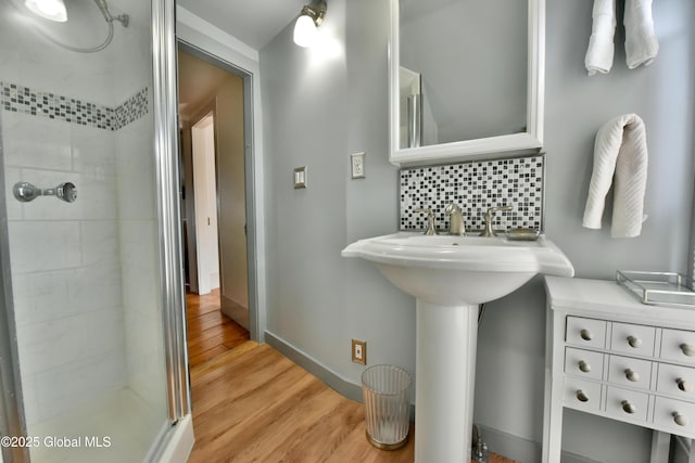21 Andrews St, Saratoga Springs, NY 12866 - full bath with a sink, a shower stall, wood finished floors, baseboards, and decorative backsplash