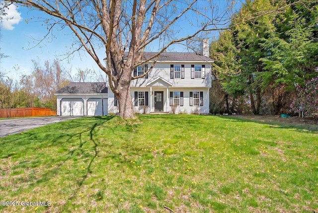 colonial inspired home with a garage, a front lawn, fence, a chimney, and driveway