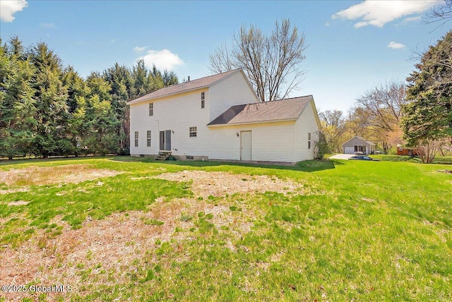 rear view of house with entry steps and a yard